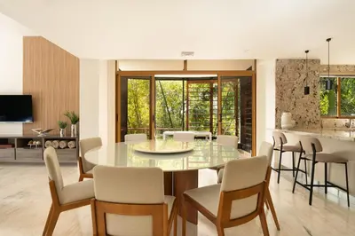 a dining room and kitchen with a glass table and chairs at Luxury 3BR Penthouse in Casa de Campo, Gated Resort Living & Golf View in La Romana