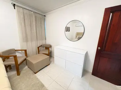 a white room with a mirror and a chair at Cómodo y moderno apartamento en Santiago Gurabo Sin costo de limpieza in Santiago de los Caballeros
