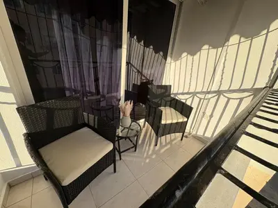 a balcony with chairs and a cat sitting on it at Cómodo y moderno apartamento en Santiago Gurabo Sin costo de limpieza in Santiago de los Caballeros