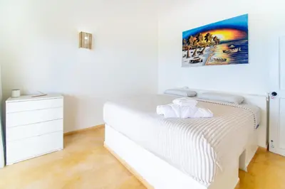 a white bedroom with a bed and a painting on the wall at Villa Bella Vista - Luxury Ocean View and Private Pool, Las Terrenas in Las Terrenas