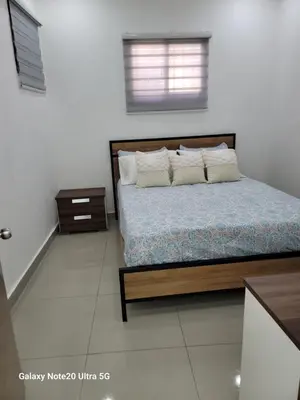 a bedroom with a bed with a wooden frame and pillows at Colonial suites in Santo Domingo