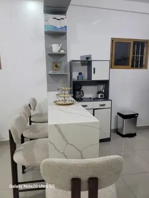 a kitchen with a white counter and chairs and a stove at Colonial suites in Santo Domingo