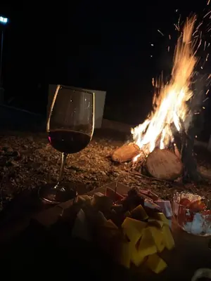 a glass of wine sitting next to a fire at La gloria