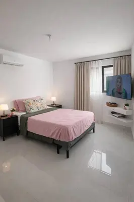 a bedroom with a bed and a television in it at Mountain and pool modern apartment in Santiago de los Caballeros