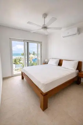 a bedroom with a bed and a large window at Sunset Calm Penthouse in Cabarete