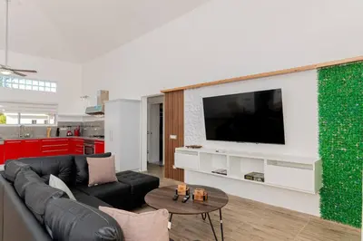 a living room with a couch and a tv on a wall at Villa Ocean Dream 3BR Oasis and guesthouse in Sosúa