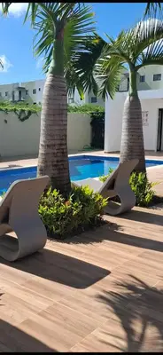 two palm trees sitting next to a swimming pool at Oasis in Graditti valley in Santiago de los Caballeros