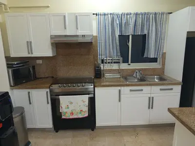 a kitchen with white cabinets and a stove and a sink at Torre chalom in Santo Domingo