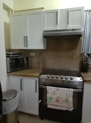 a kitchen with a stove and white cabinets at Torre shalom in Santo Domingo