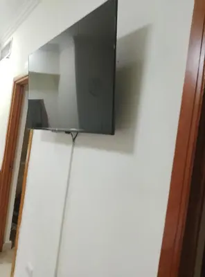 a flat screen tv on top of a refrigerator at Torre shalom in Santo Domingo