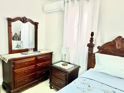 a bedroom with a bed and a dresser and a mirror at Padres Las Casa in Santiago de los Caballeros