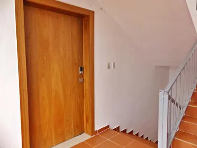 a hallway with a wooden door and stairs at Padres Las Casa in Santiago de los Caballeros