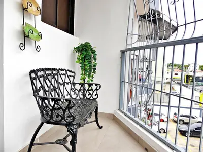 a black chair in a room with a window at Padres Las Casa in Santiago de los Caballeros