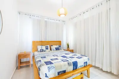 a bedroom with a bed with a blue and white comforter at Coastal Corner -Beach-Pool-Terrace-Parking-Pets in Villas del Mar