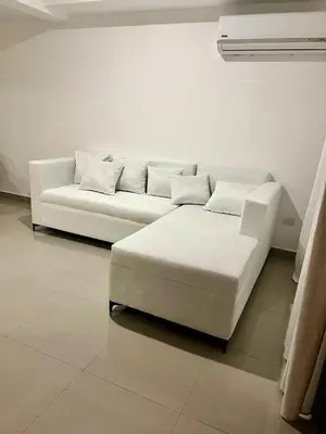 a white couch and stool in a room at Laggo one houses in Punta Cana