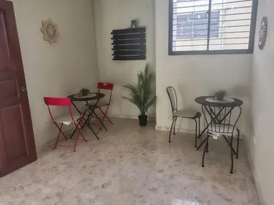 a room with two tables and chairs and a plant at Comfortable and quiet single room in Santo Domingo