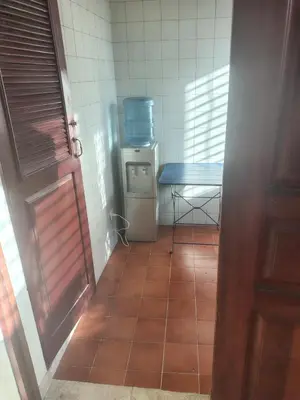 a small kitchen with a table and a tiled floor at Comfortable and quiet single room in Santo Domingo