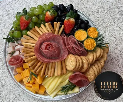 a plate of food with cheese and meats and fruit at Luxury apartment private rooftop & jacuzzi in Santo Domingo