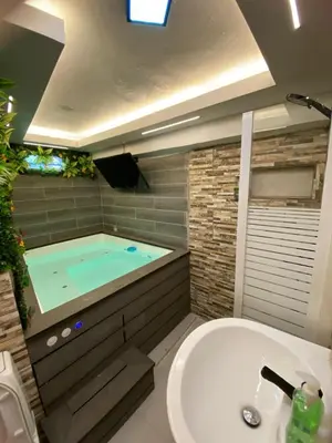 a bathroom with a jacuzzi tub and a sink at Luxury Beautiful mini apartment Private jacuzzi in Santo Domingo