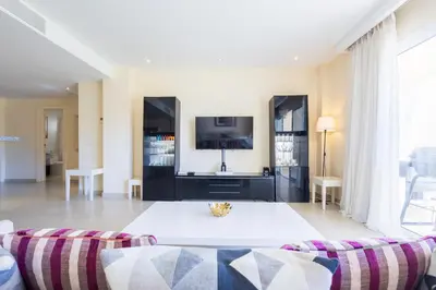 a living room with a couch and a tv at Iberostate 2BR Apartment - BBQ, Terrace, Lake & Golf Views, Beach Club Access in Punta Cana