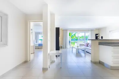 a kitchen and living room with a couch and a table at Iberostate 2BR Apartment - BBQ, Terrace, Lake & Golf Views, Beach Club Access in Punta Cana
