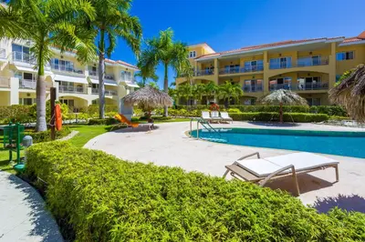 a resort with a swimming pool and palm trees at Iberostate 2BR Apartment - BBQ, Terrace, Lake & Golf Views, Beach Club Access in Punta Cana