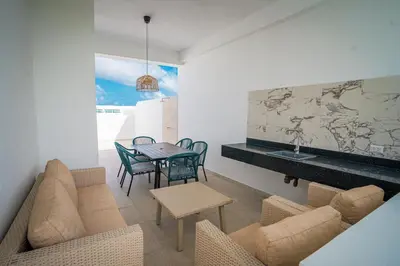 a living room with a couch and a table and chairs at Golf View Penthouse with Private Rooftop & BBQ in Punta Cana