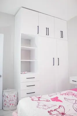a white bedroom with a bed and white cabinets at Apartamentos carrasco in Nagua