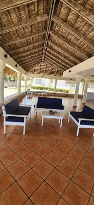 a room with couches and a table in a building at Apartamento frente al Mar y Piscina in Juan Dolio