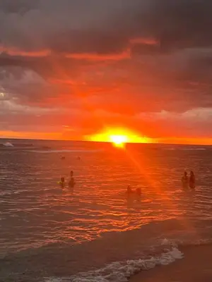 a group of people in the ocean at sunset at Apartamento frente al Mar y Piscina in Juan Dolio
