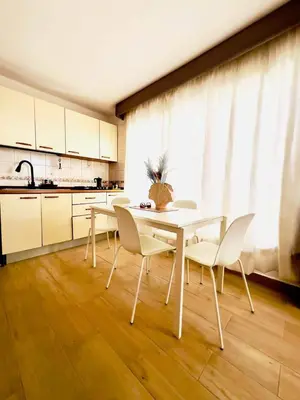 a dining room with a table and chairs and a kitchen at Apartamento frente al Mar y Piscina in Juan Dolio