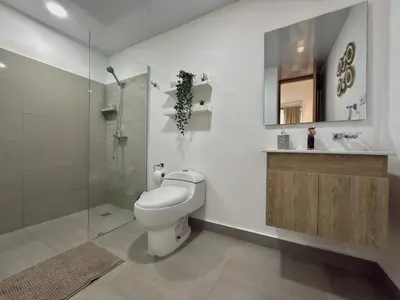 a bathroom with a toilet and a glass shower at Apartamento en livera RD in Santiago de los Caballeros