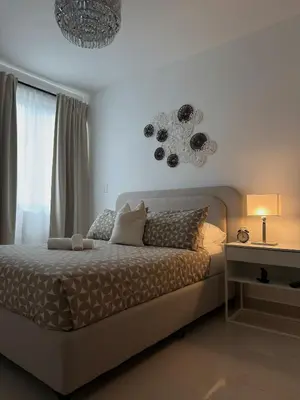 a bedroom with a bed and a chandelier at Apartamento en livera RD in Santiago de los Caballeros