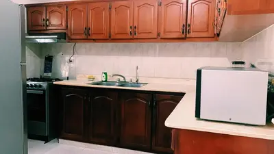 a kitchen with wooden cabinets and a sink and a refrigerator at Hacienda Francisco in Concepción de La Vega