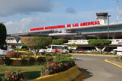 a bus is parked in front of an airport at Piscina Playa 3 Min Aeropuerto Cerca in Boca Chica