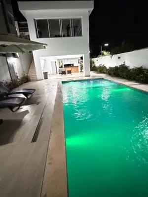 a swimming pool in front of a house at night at Piscina Playa 3 Min Aeropuerto Cerca in Boca Chica