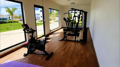 a gym with two exercise bikes in a room with windows at Villa Brisa Marina in Boca Chica