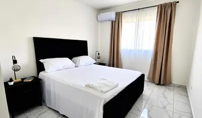 a bedroom with a white bed and a window at Villa Brisa Marina in Boca Chica