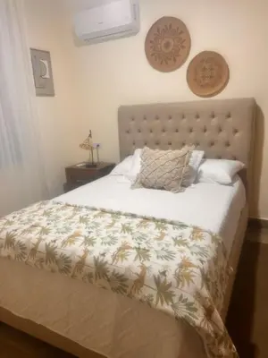 a bedroom with a bed with a comforter on it at El descanso in Higuey
