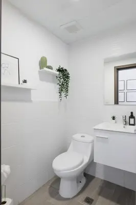 a white bathroom with a toilet and a sink at Nestled Comfort in 1BR -WeHost DR in Santo Domingo