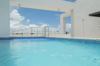 a swimming pool with blue water in a building at Nestled Comfort in 1BR -WeHost DR in Santo Domingo