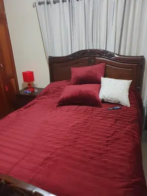 a red bed with red and white pillows on it at My house 56 in San Francisco de Macorís