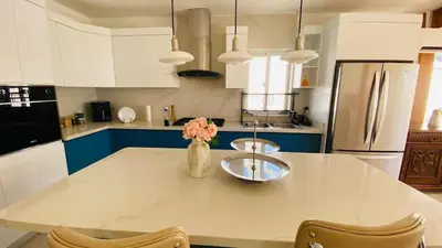 a kitchen with a table with a vase of flowers on it at Oceanfront villa with pool, Ocoa bay in Azua