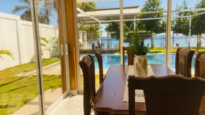 a table with a plant on it in front of a window at Oceanfront villa with pool, Ocoa bay in Azua