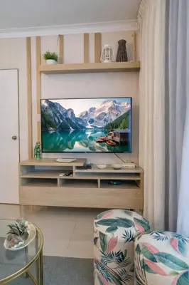 a living room with a flat screen tv on a entertainment center at ®{The-Comfty-Spot} Experience @SD WiFi in Santo Domingo