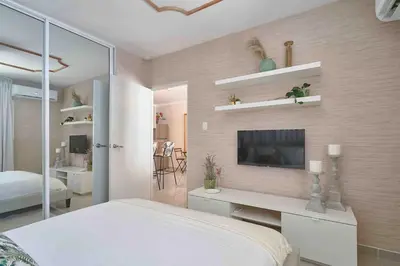 a bedroom with a bed and a tv on a wall at ®{The-Comfty-Spot} Experience @SD WiFi in Santo Domingo