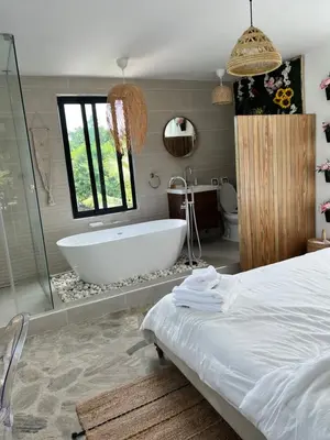 a bathroom with a bath tub and a bed at Monte y Cielo 1 apartment in Las Galeras