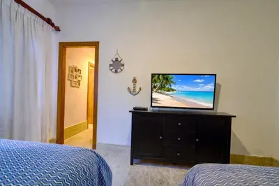a bedroom with a flat screen tv on a dresser at ®2BR{Beach~Spot} @TerrenasJaccuziWalk~to~Beach in El Limón
