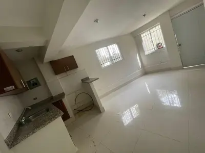 an empty kitchen with two windows and a white floor at Bohio rd in Santo Domingo