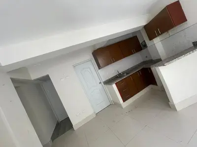 an empty kitchen with white walls and brown cabinets at Bohio rd in Santo Domingo